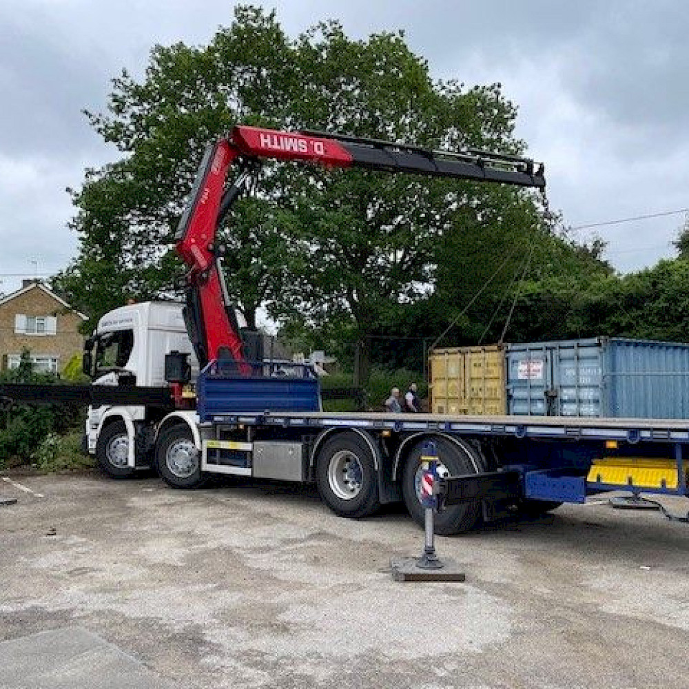 Shipping container being delivered to a site