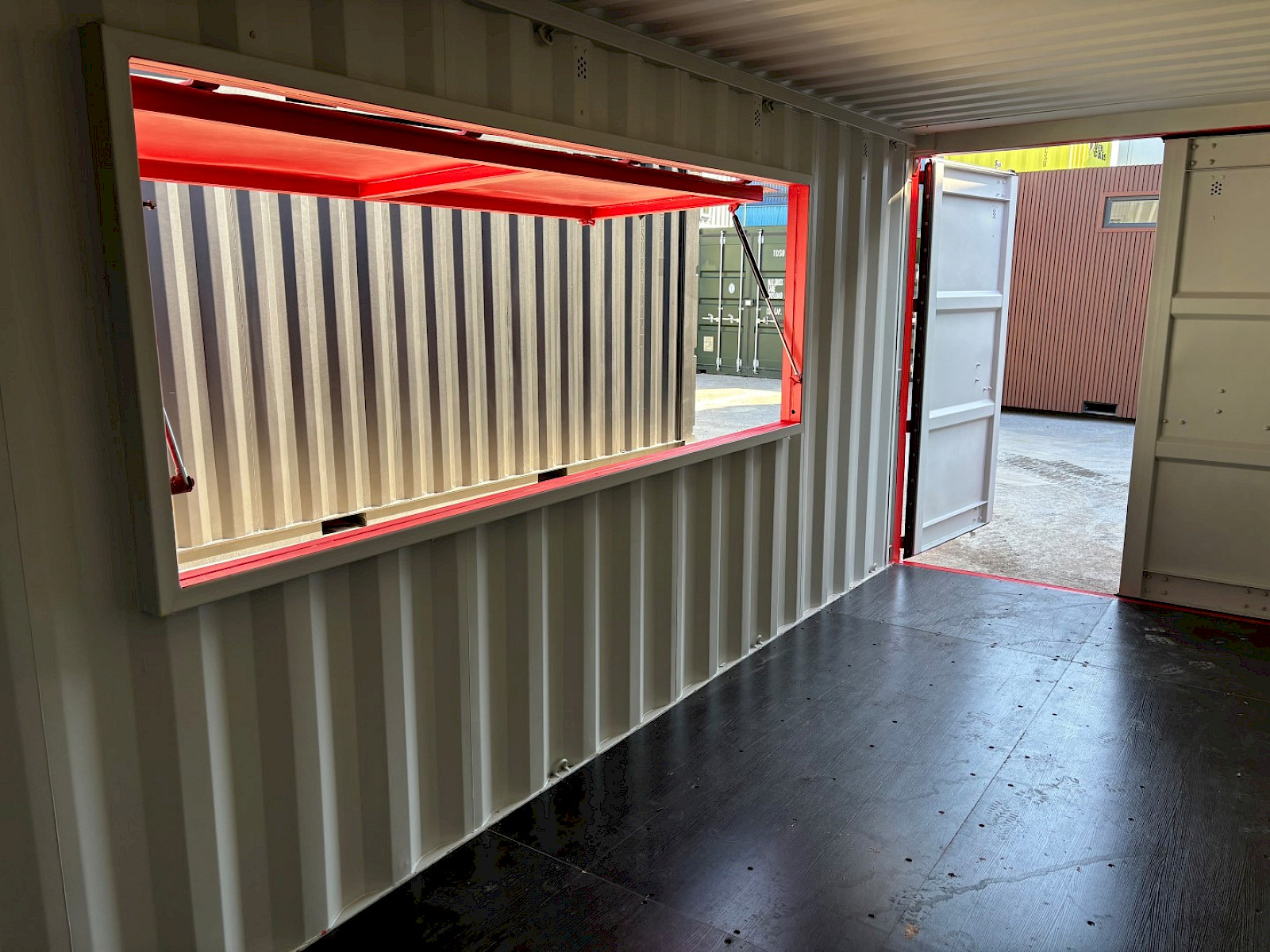 Shipping container bar with serving hatch held open